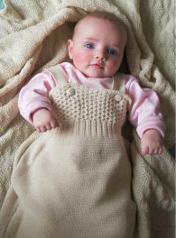 Baby in Disana's knitted organic Merino wool sleeping bag